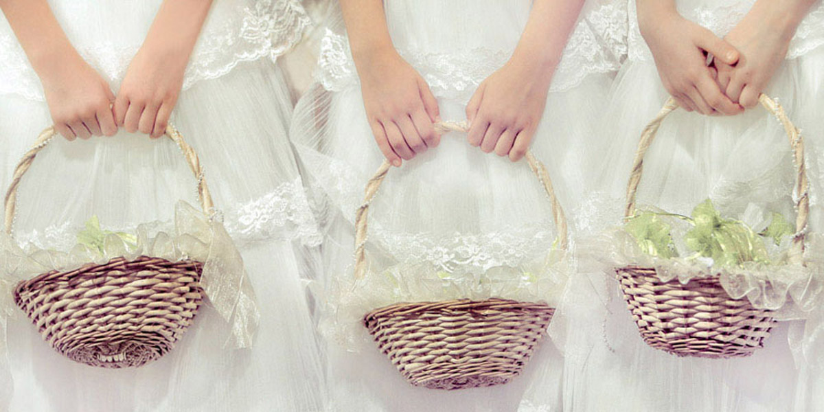 Three flower girls holding traditional baskets