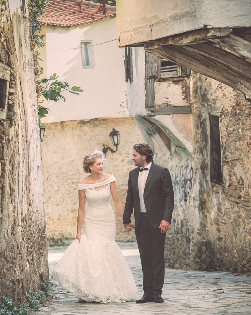 A just-married couple walking in an old Greek village